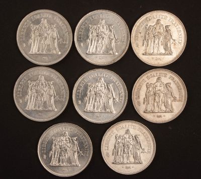 six pièces d'argent de tailles et de formes différentes sur une surface noire