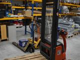 a forklift in a warehouse with pallets on the floor