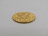 gros plan d'une pièce d'or sur une surface blanche