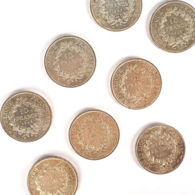 six pièces de monnaie britanniques différentes sont disposées en cercle sur une surface blanche