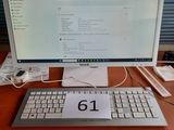 un ordinateur posé sur un bureau, avec une souris et un clavier