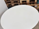 a white table with a white top in a room with pallets