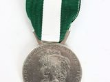 an old silver medal with a green and white ribbon on a white background