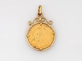 a gold coin pendant with an image of a woman on it