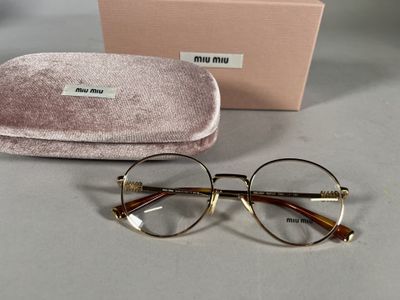 une paire de lunettes avec son étui, posée sur la table à côté d'une boîte de lunettes