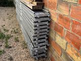 a pile of lumber stacked up against a brick wall