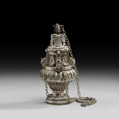 un vieux vase en argent entouré d'une chaîne, posé sur une table