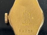 an image of a close up of a gold watch on a black surface