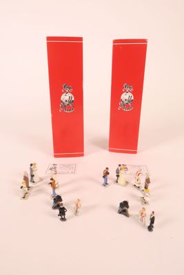 petites figurines représentant des personnes debout devant une boîte rouge