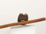 a sculpture of an apple sitting on top of a wooden stick
