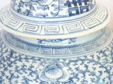 a blue and white vase with a lid on a table