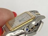 a person holding a silver and gold watch in their hand