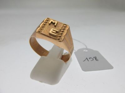 une photo d'une bague en or ornée d'une croix, à laquelle est accrochée une étiquette de prix