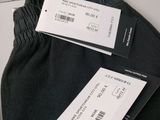 two pairs of black pants with a price tag on them