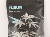 a close up of a bag of marijuana leaves on a white surface