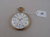 a gold pocket watch with a tag on it