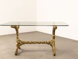 an image of a glass and brass coffee table on a concrete floor