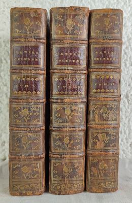 trois vieux livres sont empilés sur une table