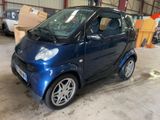 a small blue smart car parked in a garage