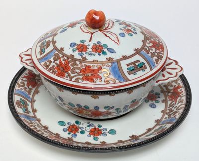 a bowl and plate with a lid on a white table