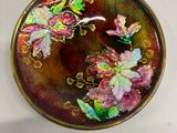 une photo d'une assiette décorative sur laquelle sont peints des fleurs et des papillons