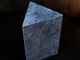 a stone block sitting on a table next to a lit candle