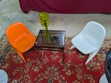 trois chaises et une table sur laquelle se trouve un vase