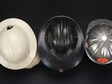 three hard hats and a hard hat on a black background