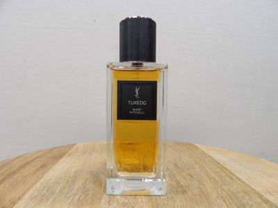 an image of a bottle of perfume sitting on top of a wooden table