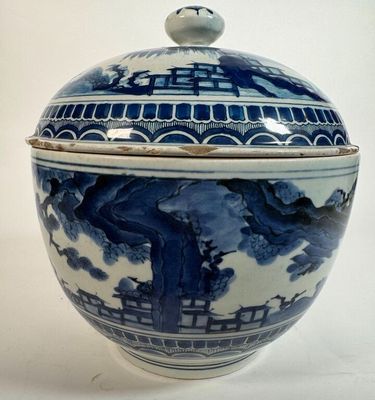 a blue and white bowl with a lid on a white table