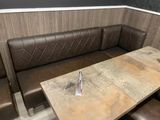 a table and bench in the corner of a booth