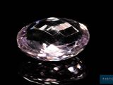 a close up of a pink diamond on a black surface