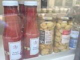 bottles of ketchup and other condiments in a glass case