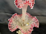 a glass vase with a pink flower on top of it