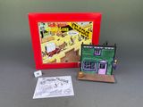 doll house in a red box with a picture of a man and woman outside