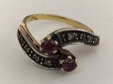 a close up of a gold and silver ring with two ruby stones
