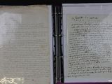 an open book with a handwritten letter on it sitting on a table