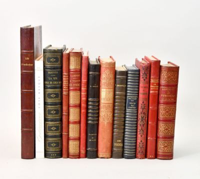 several old books are lined up in a row on a white surface