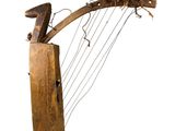 an old wooden musical instrument with a long neck and a wooden handle