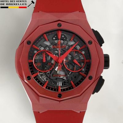 La montre est rouge et noire, avec un cadran noir.