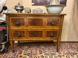 a wooden chest of drawers with a bowl on top of it