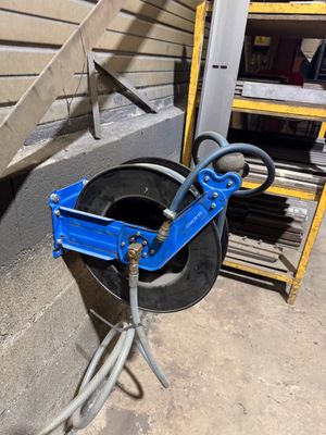 une photo d'un coupe-tube bleu à côté d'une pile de pneus