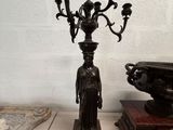a statue of a woman standing next to a candelabra