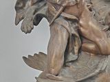a bronze statue of a man holding a fish
