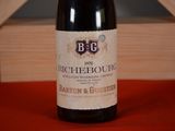 a bottle of wine sitting on a table next to a wooden box