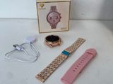 a pink watch and a pink bracelet on a white table