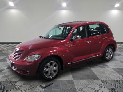 La Chrysler PTX rouge est garée sur un sol en carrelage à damier.