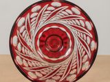 a red and white glass bowl on a wooden table