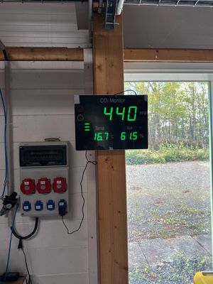 a digital clock on the wall in a garage