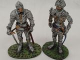 two figurines of soldiers with weapons on a white surface